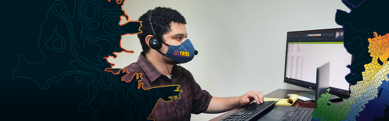 A professional sits in a home office, having a video conference with many coworkers