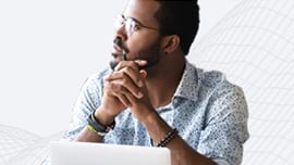 Young man wearing glasses in front of a laptop